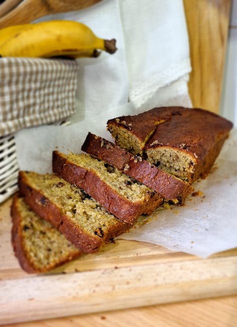 Freshly baked banana bread slices displayed on a wooden board, perfect for breakfast or snack.